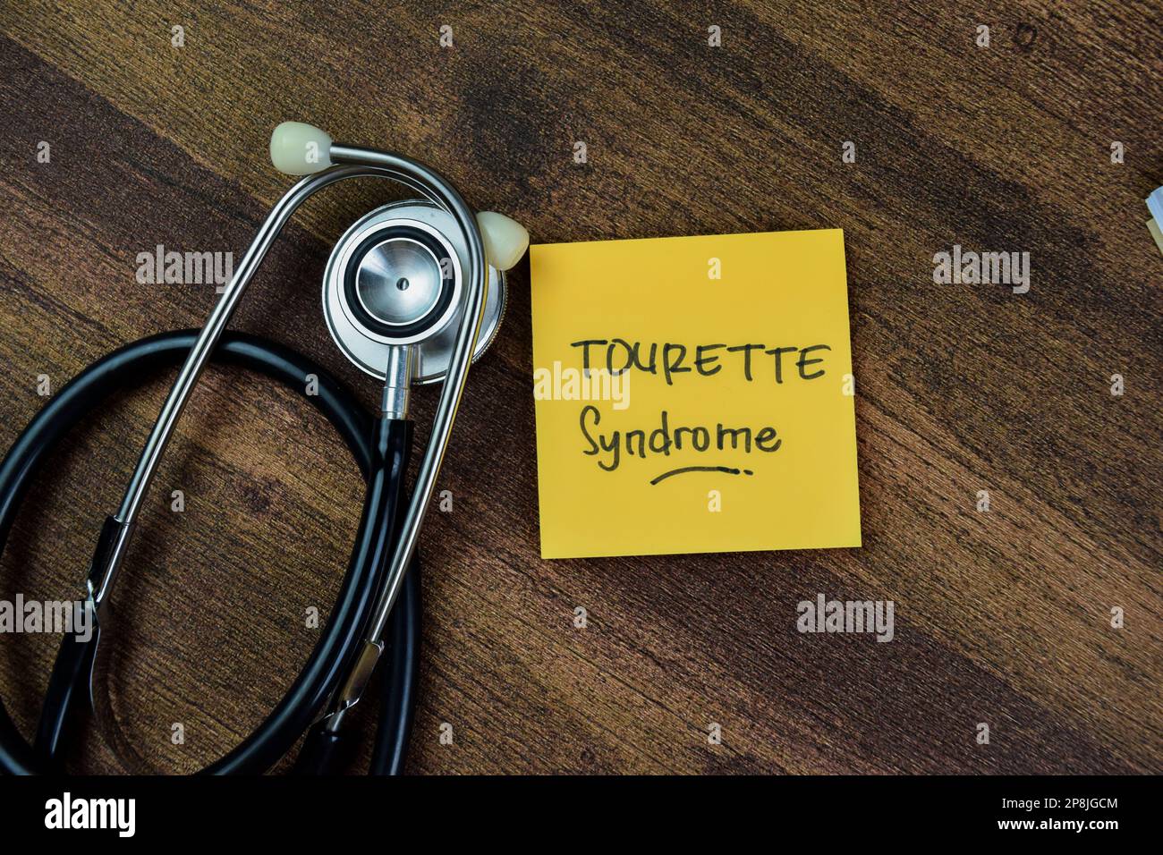 Konzept des Tourette-Syndroms Schreiben Sie auf Haftnotizen mit Schlüsselwörtern, die auf dem Holztisch isoliert sind. Stockfoto