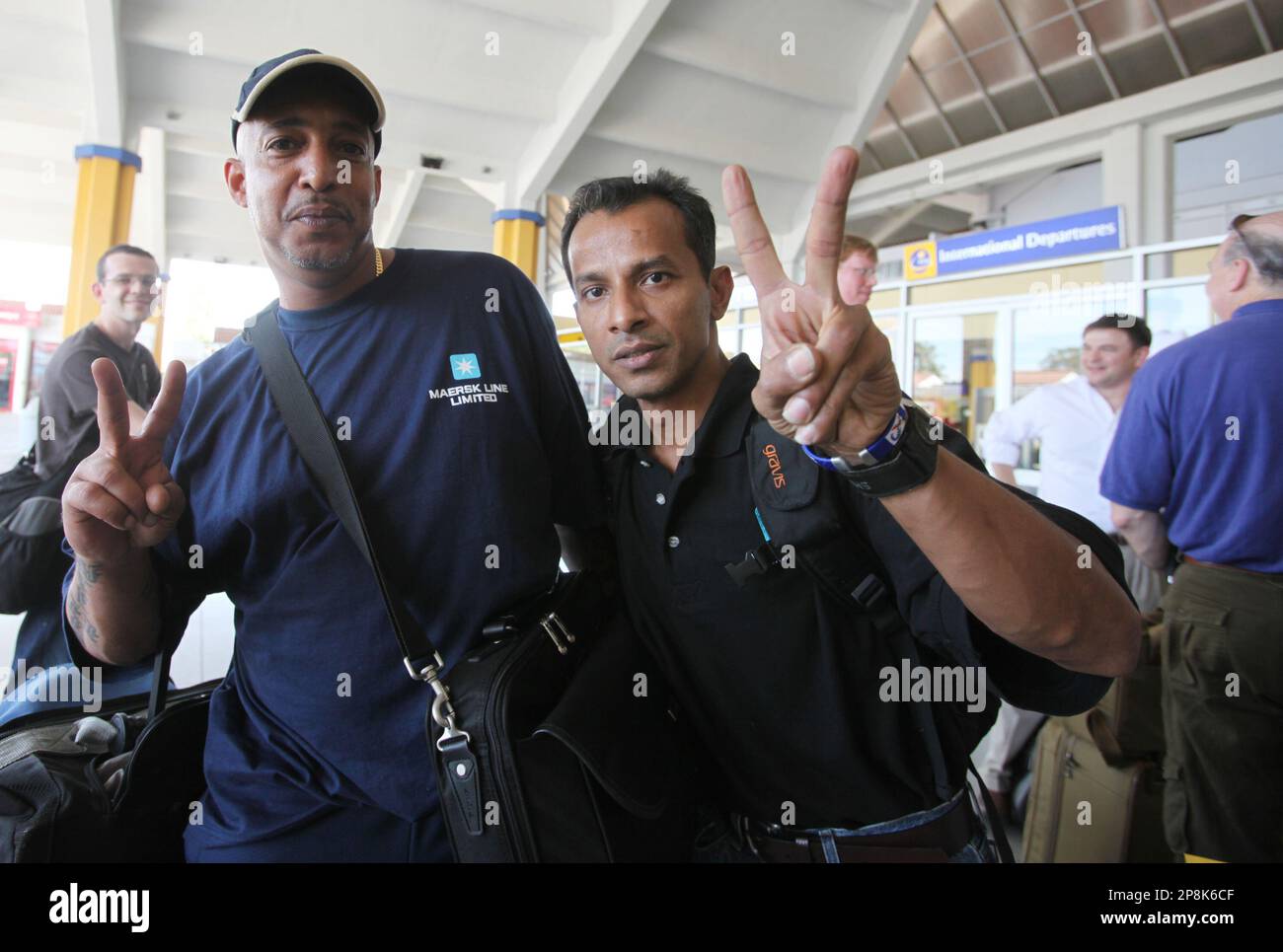 Crew members of the merchant vessel, Maersk Alabama which was confronted by Somali pirates, wave victory signs as they wait at the international airport at Mombasa, Kenya, Wednesday, April 15, 2009. The crew of the U.S. freighter that thwarted a pirate attack are at Mombasa airport preparing to return home, according to Maersk shipping line officials. Their captain, Richard Phillips, who remained with the pirates was rescued by U.S.Navy SEALs Sunday.(AP Photo/Sayyid Azim) Stockfoto