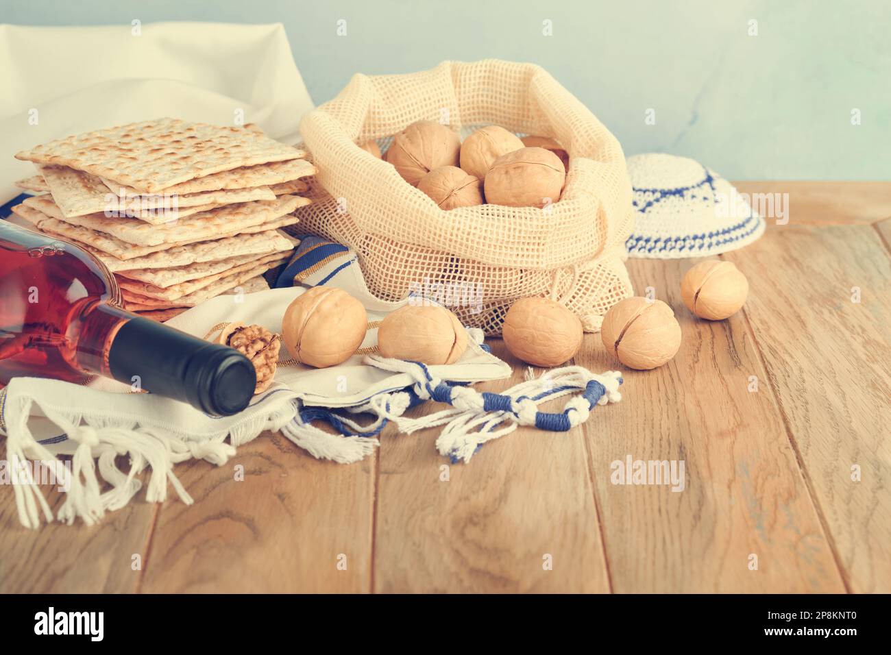 Das Konzept der Pessachstunde. Matzah, roter Koscher und Walnuss. Traditionelles jüdisches Brot Matzah, Kippah und Tallit auf altem Holzhintergrund. Passo Stockfoto