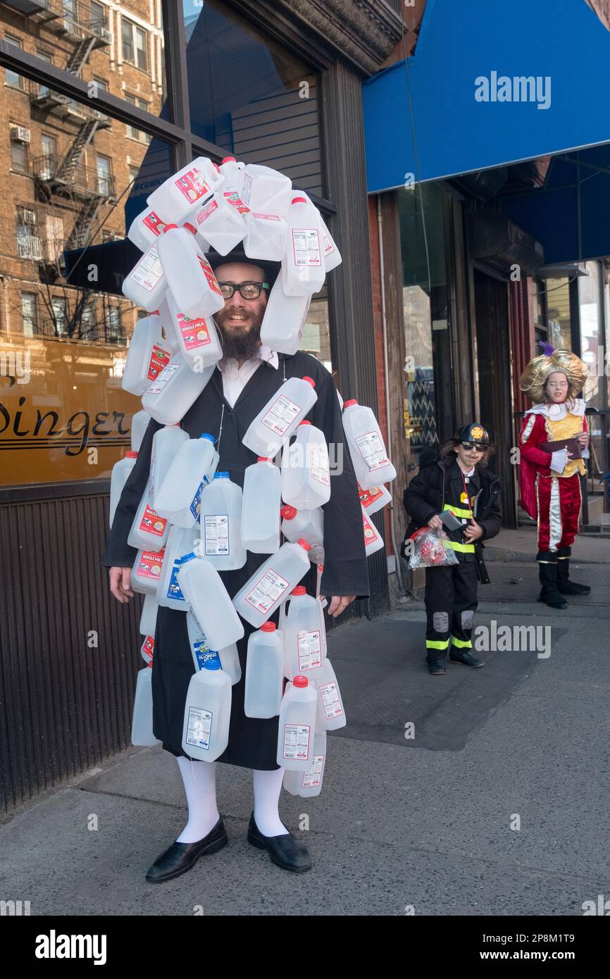 Ein orthodoxer jüdischer Mann mit einem fantastischen Purim-Kostüm aus Dutzenden leerer Plastikmilchflaschen. In Williamsburg, Brooklyn, NYC. Stockfoto