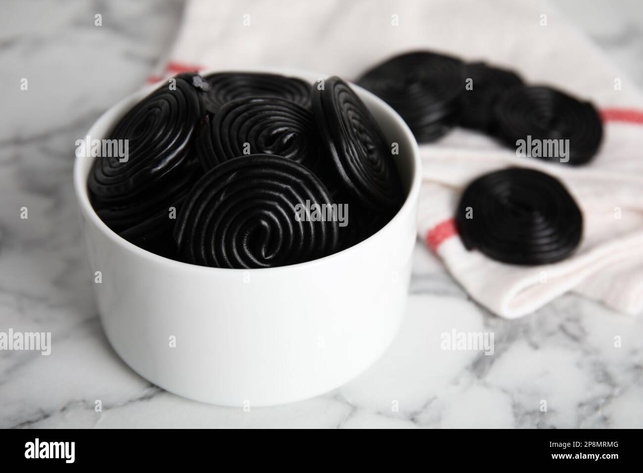 Leckere schwarze Süßigkeiten auf weißem Marmortisch, Nahaufnahme Stockfoto