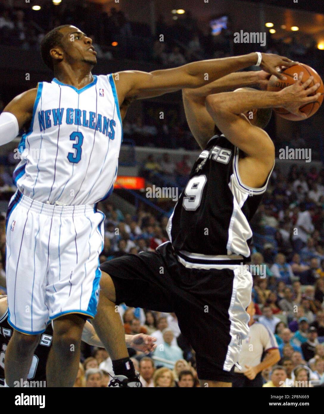 New Orleans Hornets guard Chris Paul (3) tries to block a shot by San Antonio Spurs guard Tony Parker (9), of France, during the first half of an NBA basketball game Sunday, March 29, 2009, in New Orleans. .(AP Photo/Brian Lawdermilk) Stockfoto