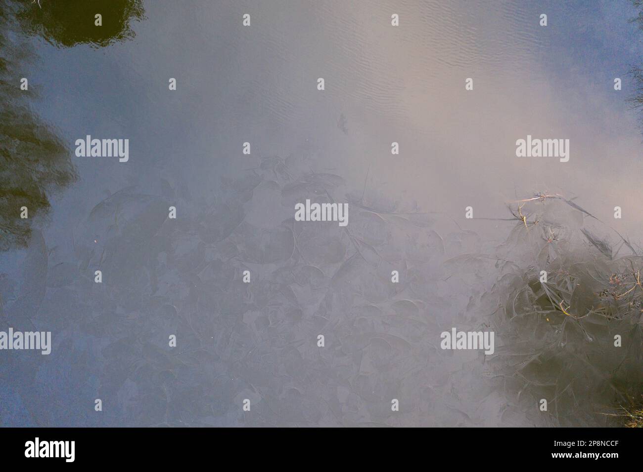 Drohnenfotografie von fließendem Fluss und Eis auf der Oberseite während des bewölkten Wintertags Stockfoto