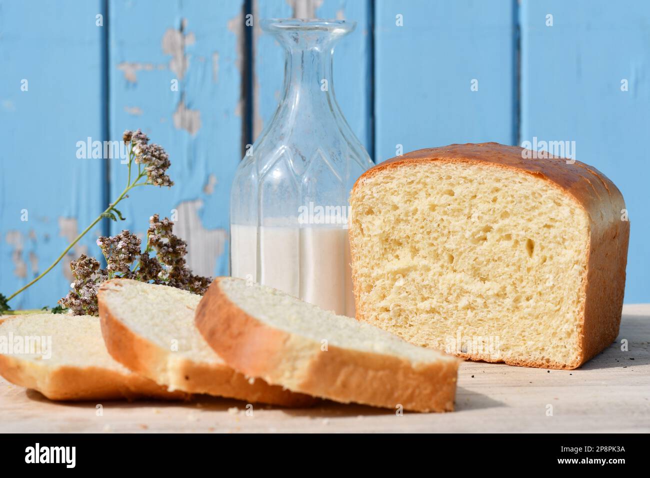 Geschnittenes Brot auf einem Schneidebrett mit blauem Holzhintergrund Stockfoto
