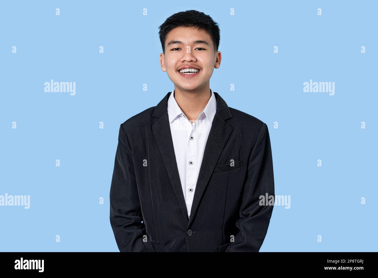 Porträt eines jungen, gutaussehenden asiatischen Geschäftsmannes isoliert auf blauem Hintergrund Stockfoto