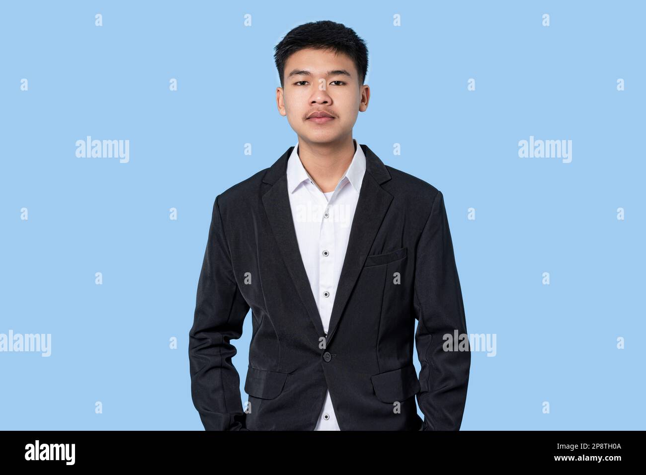 Porträt eines jungen, gutaussehenden asiatischen Geschäftsmannes isoliert auf blauem Hintergrund Stockfoto