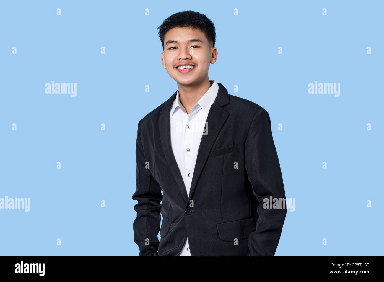 Porträt eines jungen, gutaussehenden asiatischen Geschäftsmannes isoliert auf blauem Hintergrund Stockfoto