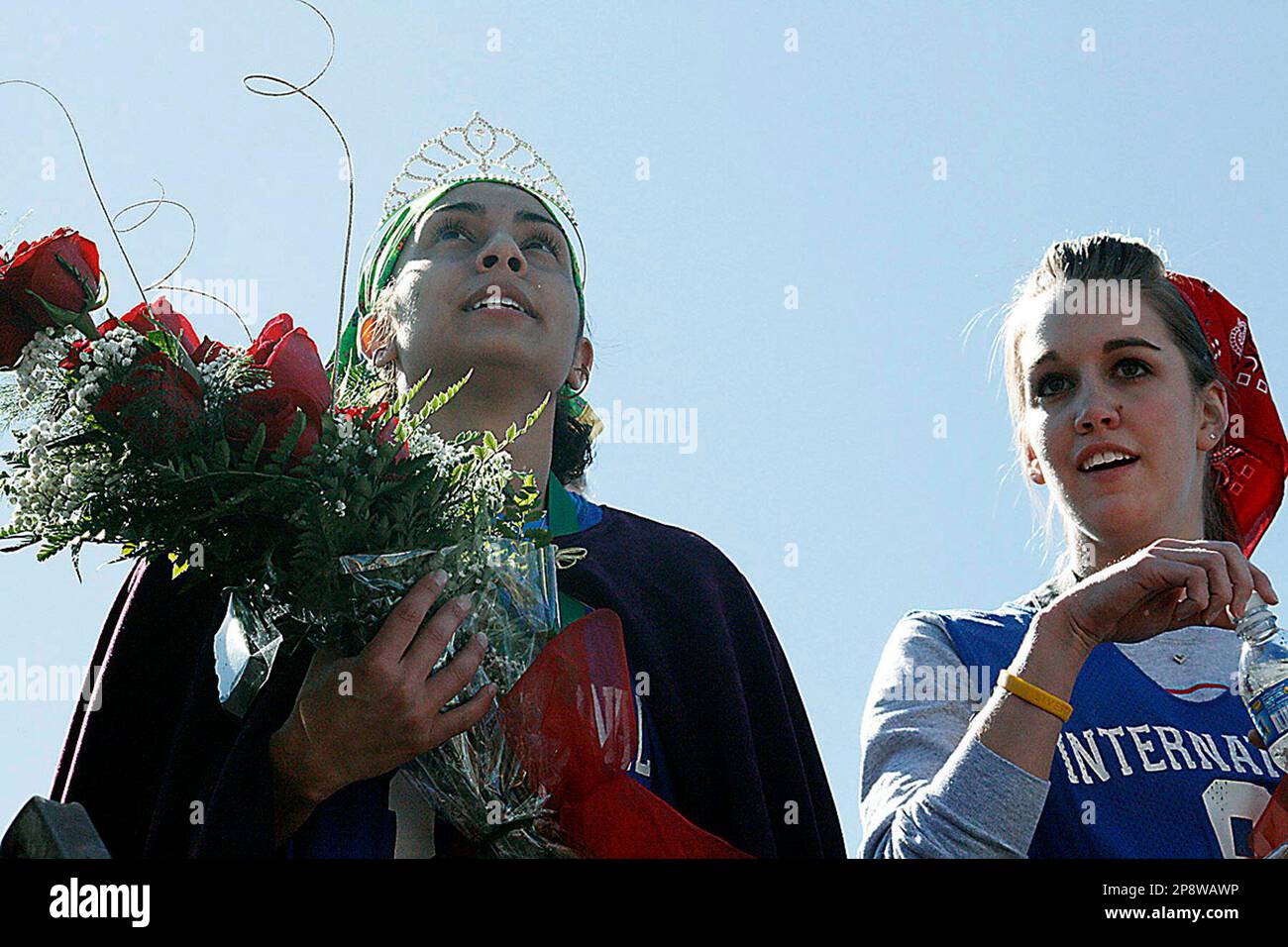 Tasha Gallegos, left, and Michelle McNabb look over the large crowd from the winner’s stage Tuesday, Feb. 24, 2009, after finishing first and second, respectively, in the International Pancake Day Race, Liberal, Kan. Gallegos broke an all-time record by finishing the race in 57.5 seconds.(AP Photo/High Plains Daily Leader,Earl Watt) Stockfoto