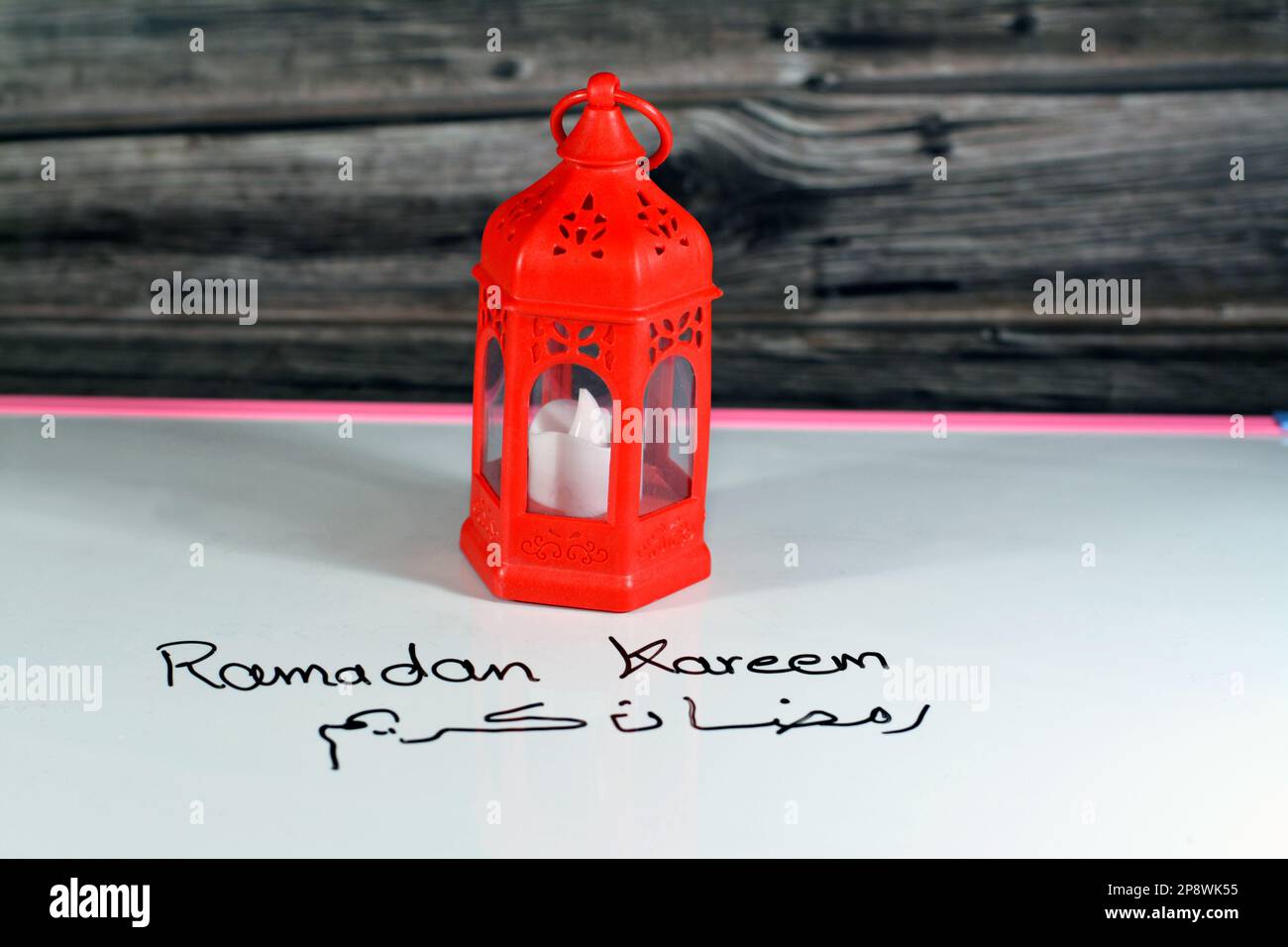 Ramadan Kareem Text in arabischer und englischer Handschrift auf einem Brett als festliche Dekoration für den Fastenmonat für Muslime festlich von Fanous Laterne I. Stockfoto