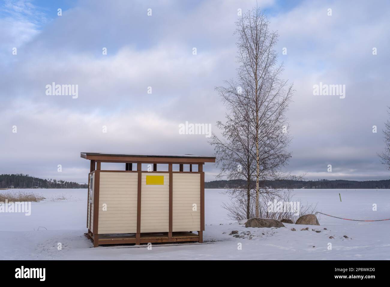 Umkleidekabinen aus Holz am finnischen Strand im Winter. Hollola, Finnland. Stockfoto