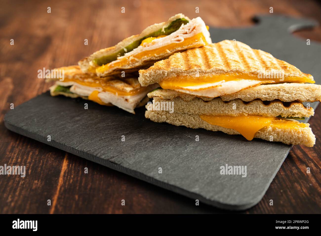 Sandwiches mit Schinken und Käse und Salas auf schwarzem Schiefer Stockfoto