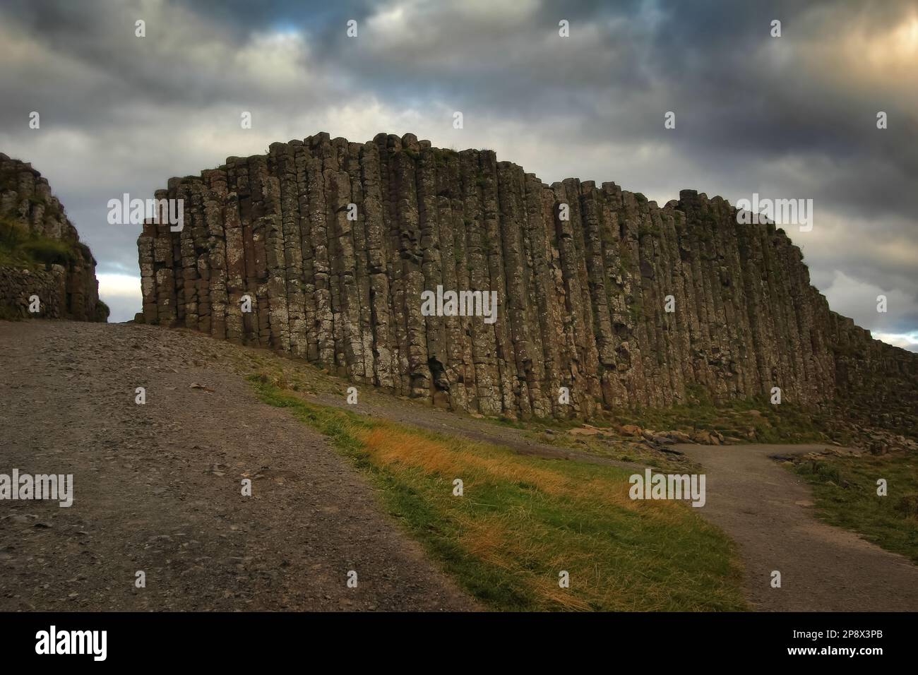 Basaltsäulen am Giant's Causeway in Nordirland mit dramatisch bewölktem Himmel Stockfoto