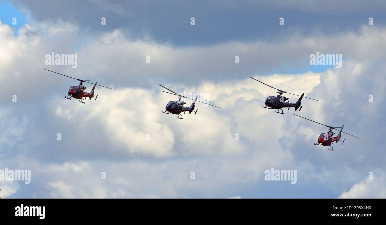 ICKWELL, BEDFORDSHIRE, ENGLAND - 03. JULI 2022: Vier Aérospatiale Gazelle Helikopter im Flug gegen Cloudy Sky. Stockfoto