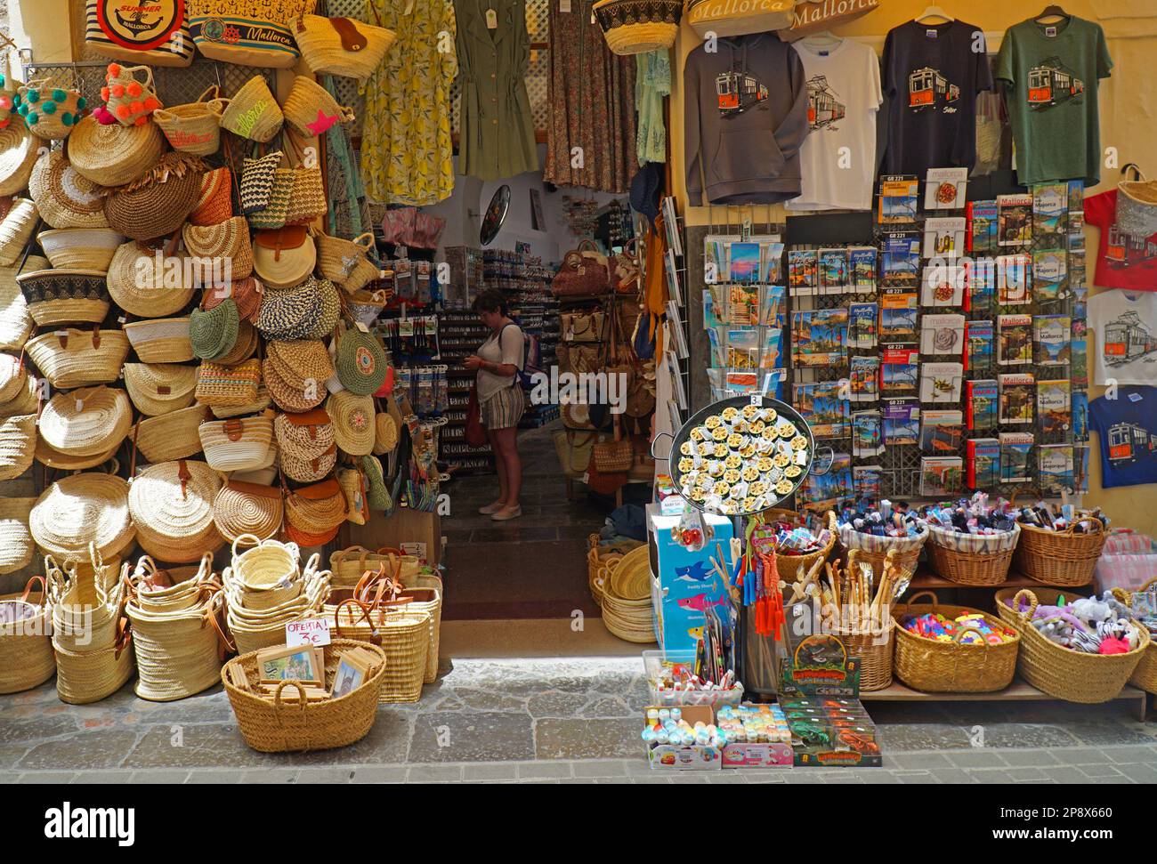 SOLLER, MALLORCA, SPANIEN - 21. JUNI 2022: Shop Auslage Wicker Körbe und Taschen T-Shirts und Bücher. Stockfoto