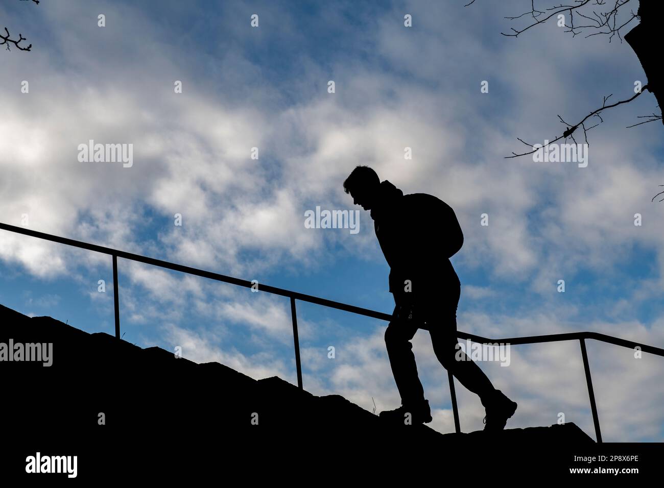 Ein Mann mit Silhouette geht einige Stufen hinauf Stockfoto