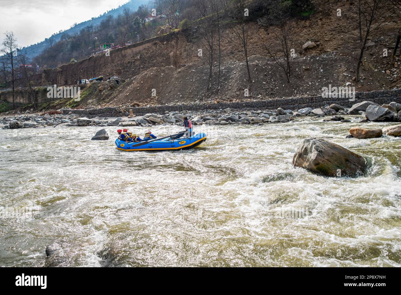 02-10-2019 Himachal Pradsk, Indien. Rafting auf dem Fluss Beas: Große Steine im Wasser. Oben auf der Straße - ein Gummiboot auf dem Dach eines Passagiers ca. Stockfoto