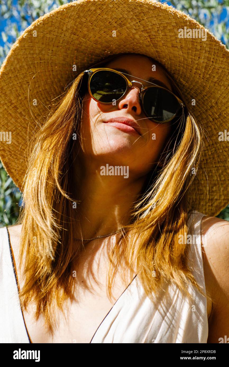Eine Nahaufnahme einer schönen Frau, die eine Sonnenbrille und einen Sonnenhut an einem sonnigen Tag in Kalifornien trägt. Stockfoto