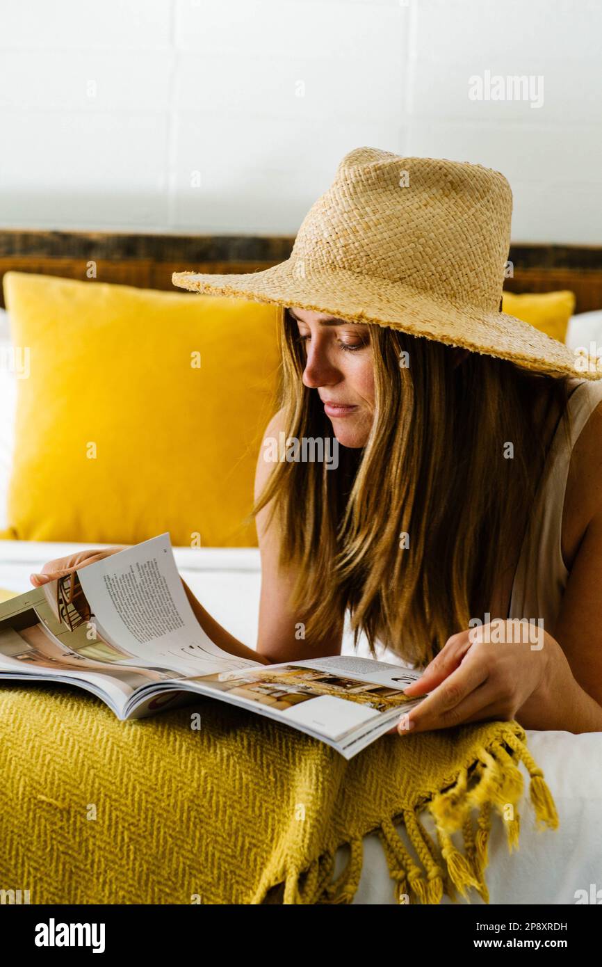 Eine Frau liegt auf ihrem Hotelzimmerbett Stockfoto