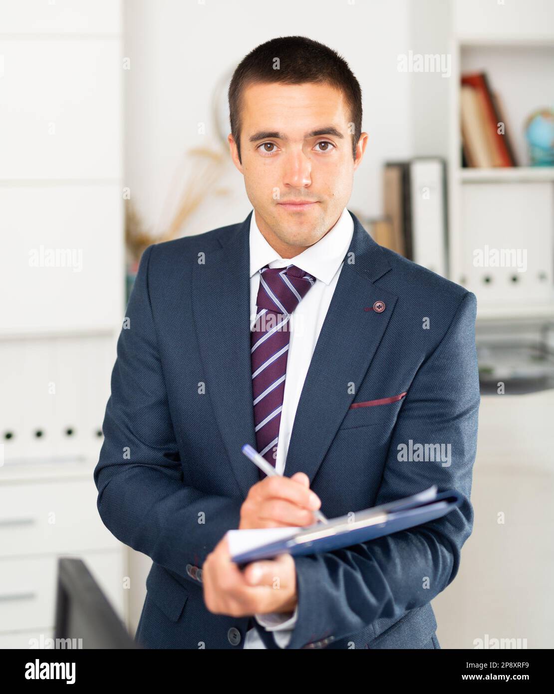 Porträt eines positiven Geschäftsmanns mit Dokumentenmappe Stockfoto