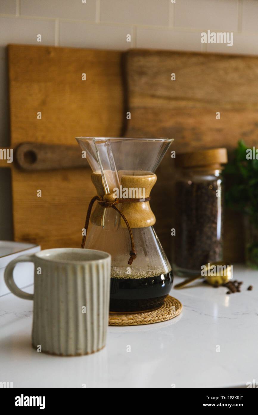 Kaffeestation Moment mit frischen Bohnen und Chemex mit Keramikbecher auf der Küchentheke Stockfoto