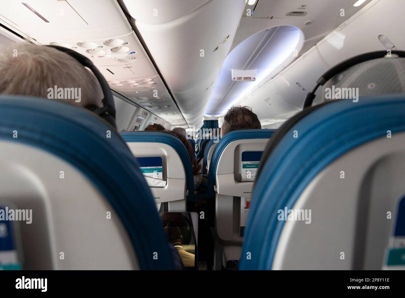 Mit Blick auf die Innenseite der Vorderseite eines Passagierflugzeugs zwischen Sitzreihen Stockfoto