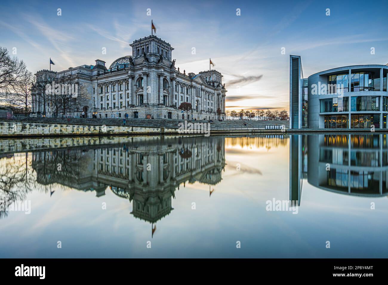Regierungsbezirk in Berlin an einem Wintertag. Reichstag und Paul Löbe Haus am Abend bei Sonnenuntergang. Spree mit Reflexion auf der Wasseroberfläche Stockfoto
