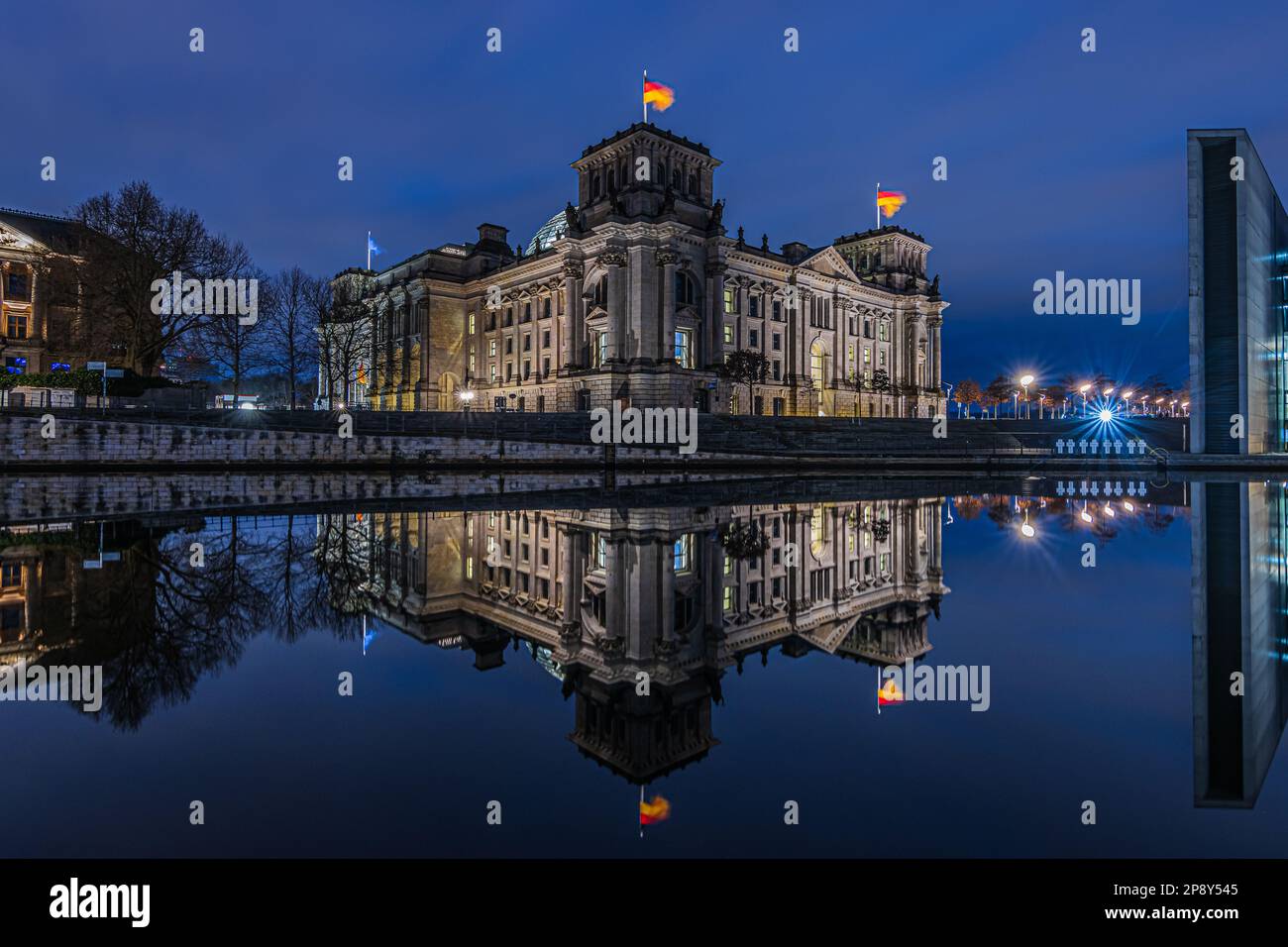 Blue Hour im Regierungsbezirk Berlin. Reichstag in der Hauptstadt Deutschlands. Spree im Stadtzentrum mit Reflexion aus dem Gebäude Stockfoto