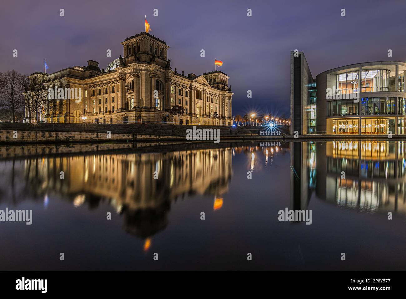 Blick auf Regierungsgebäude bei Nacht. Reichstag in Berlin zur blauen Stunde. Beleuchtete historische Gebäude. Spree mit Reflexion auf dem Wasser Stockfoto