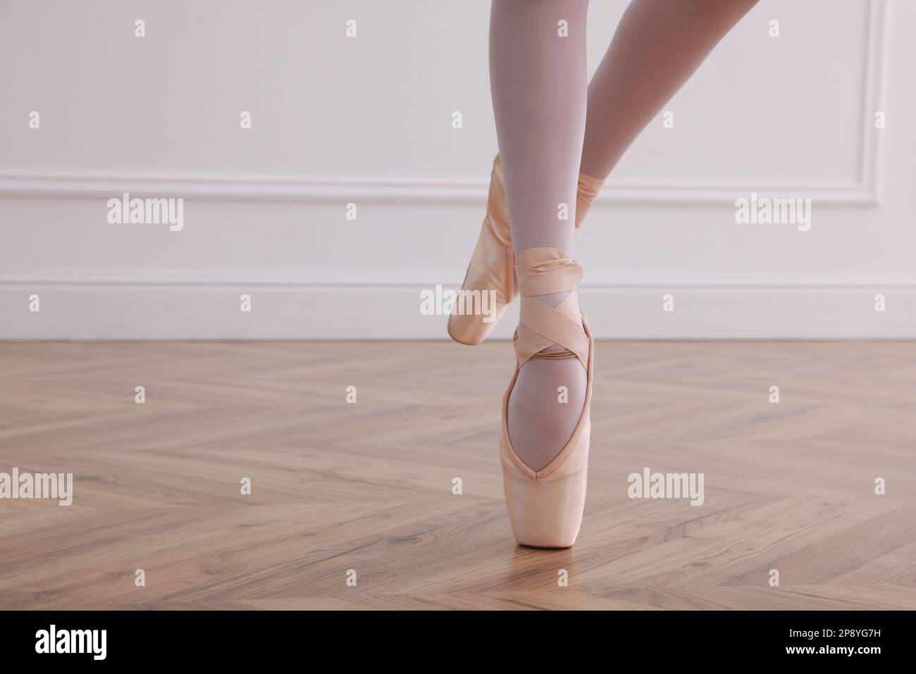 Kleine Ballerina, die Tanzbewegungen im Studio übt, die Beine schließen. Platz für Text Stockfoto