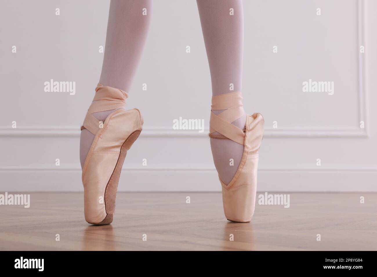 Kleine Ballerina, die Tanzbewegungen im Studio übt, die Beine schließen Stockfoto