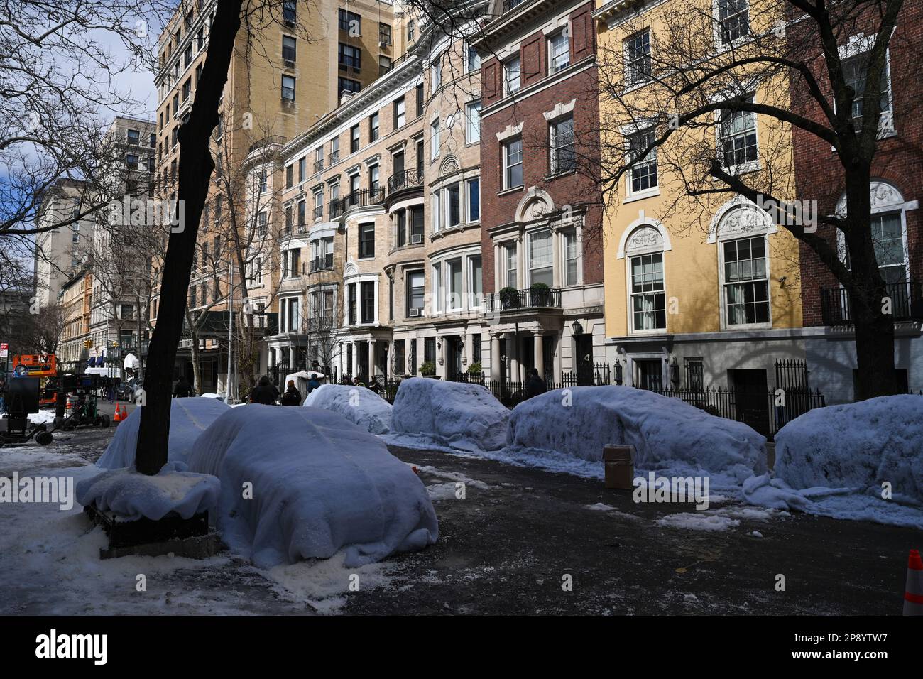 Auf einem Filmset entlang der 82. Street in der Upper East Side von New York City sind die Autos mit falschem Schnee bedeckt. Stockfoto