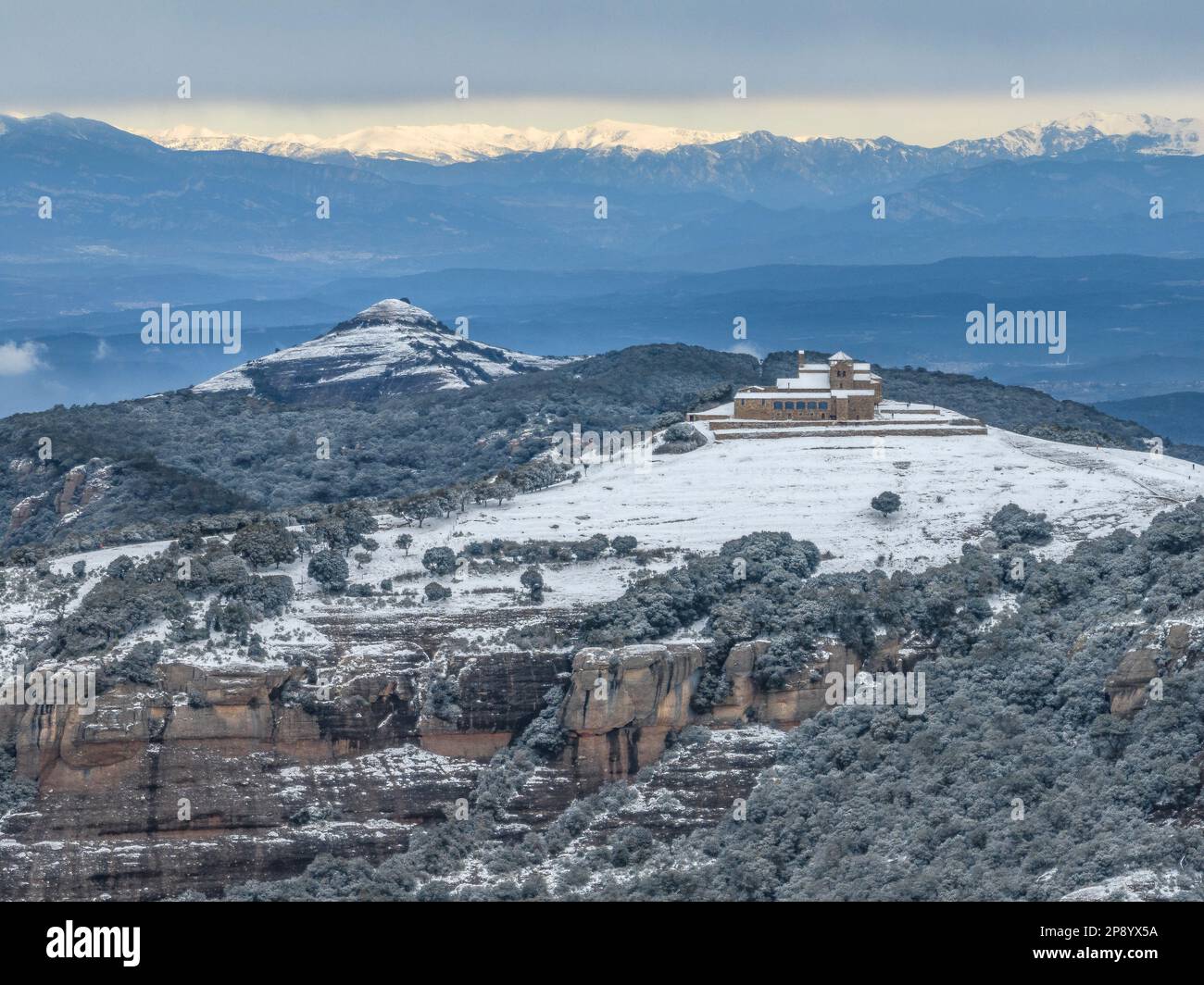 Luftaufnahme der verschneiten Gipfel von Montcau und La Mola (mit dem Kloster Sant Llorenc del Munt) auf der 02-27-2023. Im Hintergrund die Pyrenäen Stockfoto