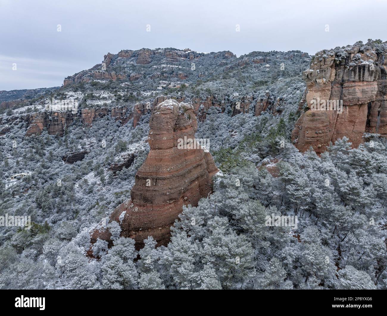 Luftaufnahme des verschneiten La Mola Berges und des Cavall Bernat de Matadepera Felsens nach dem Schneefall von 02-27-2023 (Matadepera, Katalonien, Spanien) Stockfoto