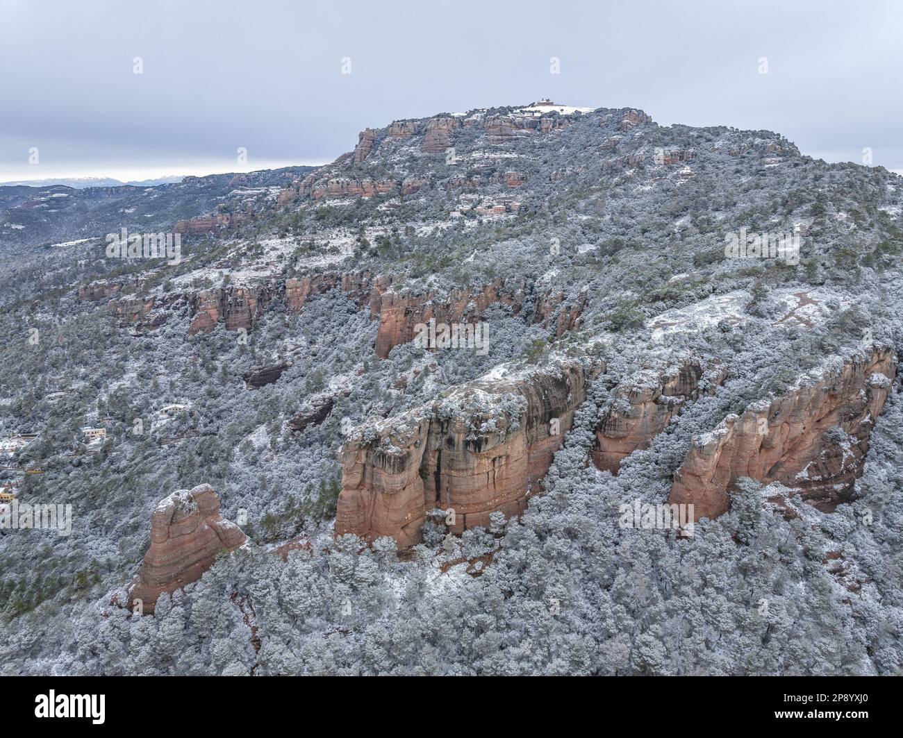 Luftaufnahme des verschneiten La Mola Berges und des Cavall Bernat de Matadepera Felsens nach dem Schneefall von 02-27-2023 (Matadepera, Katalonien, Spanien) Stockfoto