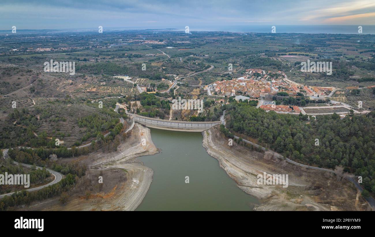 Blick aus der Vogelperspektive auf das Riudecanyes-Reservoir und das Dorf mit sehr niedrigem Wasserstand während der Dürre 2022-23 (Baix Camp, Tarragona, Katalonien, Spanien) Stockfoto
