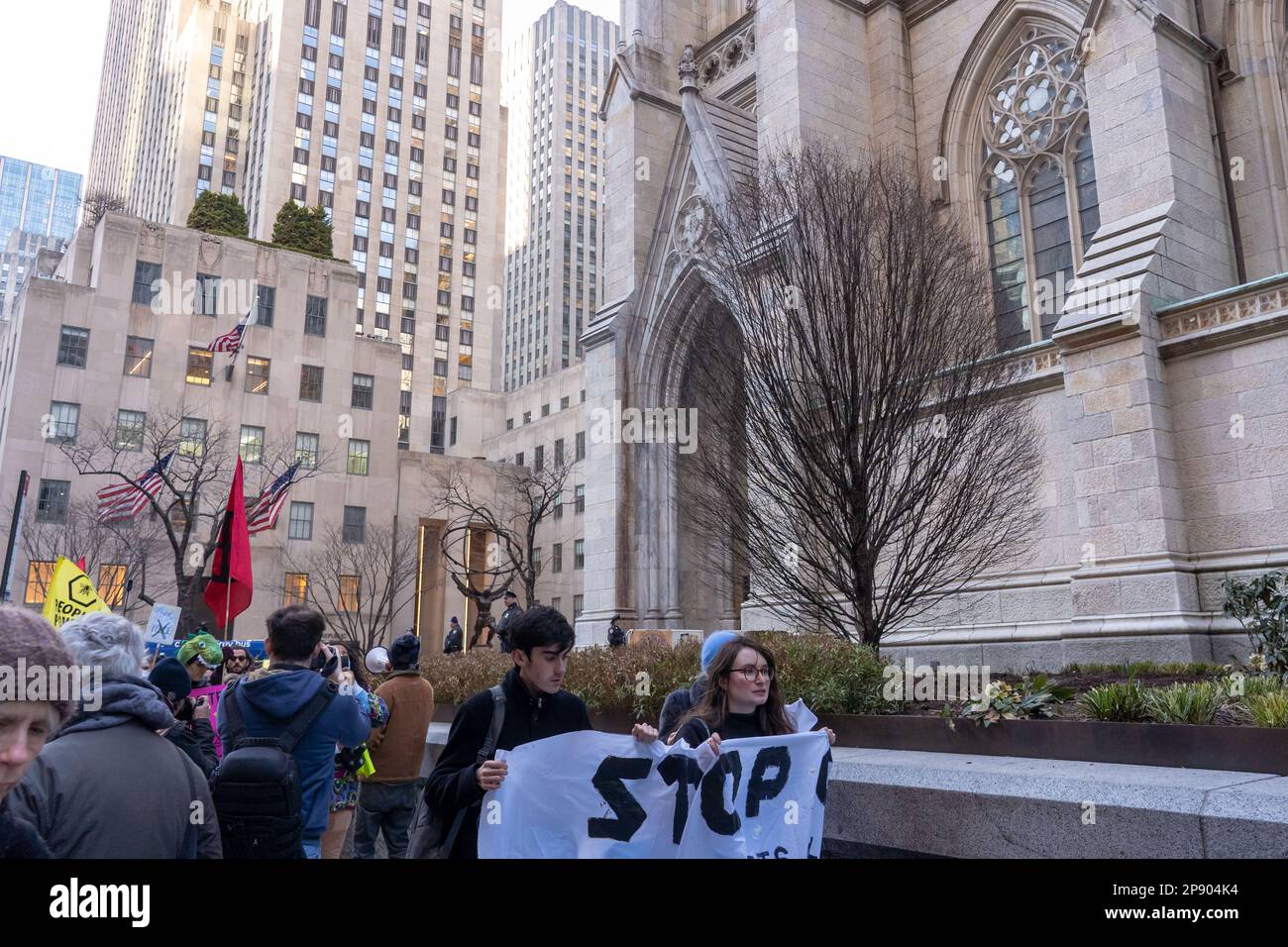 NEW YORK, NEW YORK - MÄRZ 09: Demonstranten mit Schildern, Bannern und Flaggen marschieren von der Saint Patrick Cathedral nach Osten während eines Protests gegen die vorgeschlagene Cop City, die am 09. März 2023 in einem Atlanta-Wald in New York City gebaut wird. COP City, eine riesige Polizeiausbildungseinrichtung, die auf einem Waldgebiet im Raum Atlanta, Georgia, im Bau ist, ist zu einem Schwerpunkt der Demonstrationen geworden, die der Entwicklung in einem der unberührtesten Wälder des Bundesstaates entgegenstehen. Das $90-Millionen-Dollar-Ausbildungszentrum soll die Polizei in militarisierter städtischer Kriegsführung ausbilden. Stockfoto