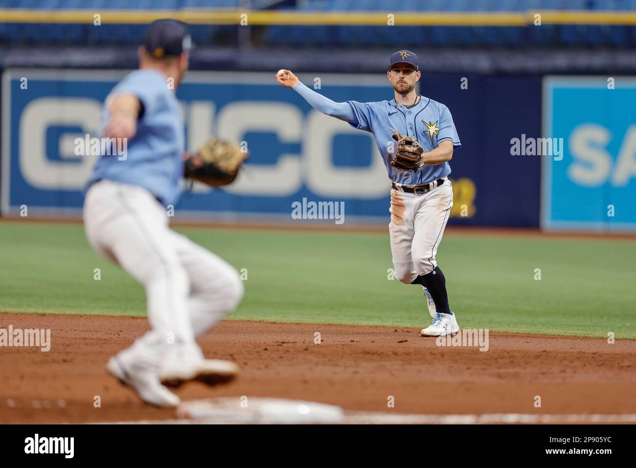 Tampa Bay strahlt den zweiten Baseman Brandon Lowe (8) aus und wirft während eines MLB-Frühjahrstrainings gegen den ersten Baseman Luke Raley (55) Stockfoto