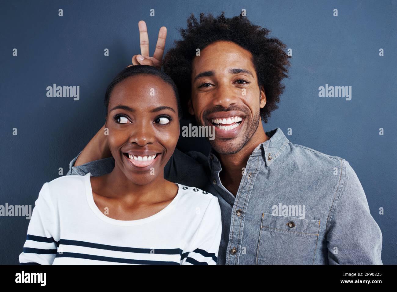 Sie ist mein Häschen. Porträt eines skurrilen Paares auf grauem Hintergrund. Stockfoto