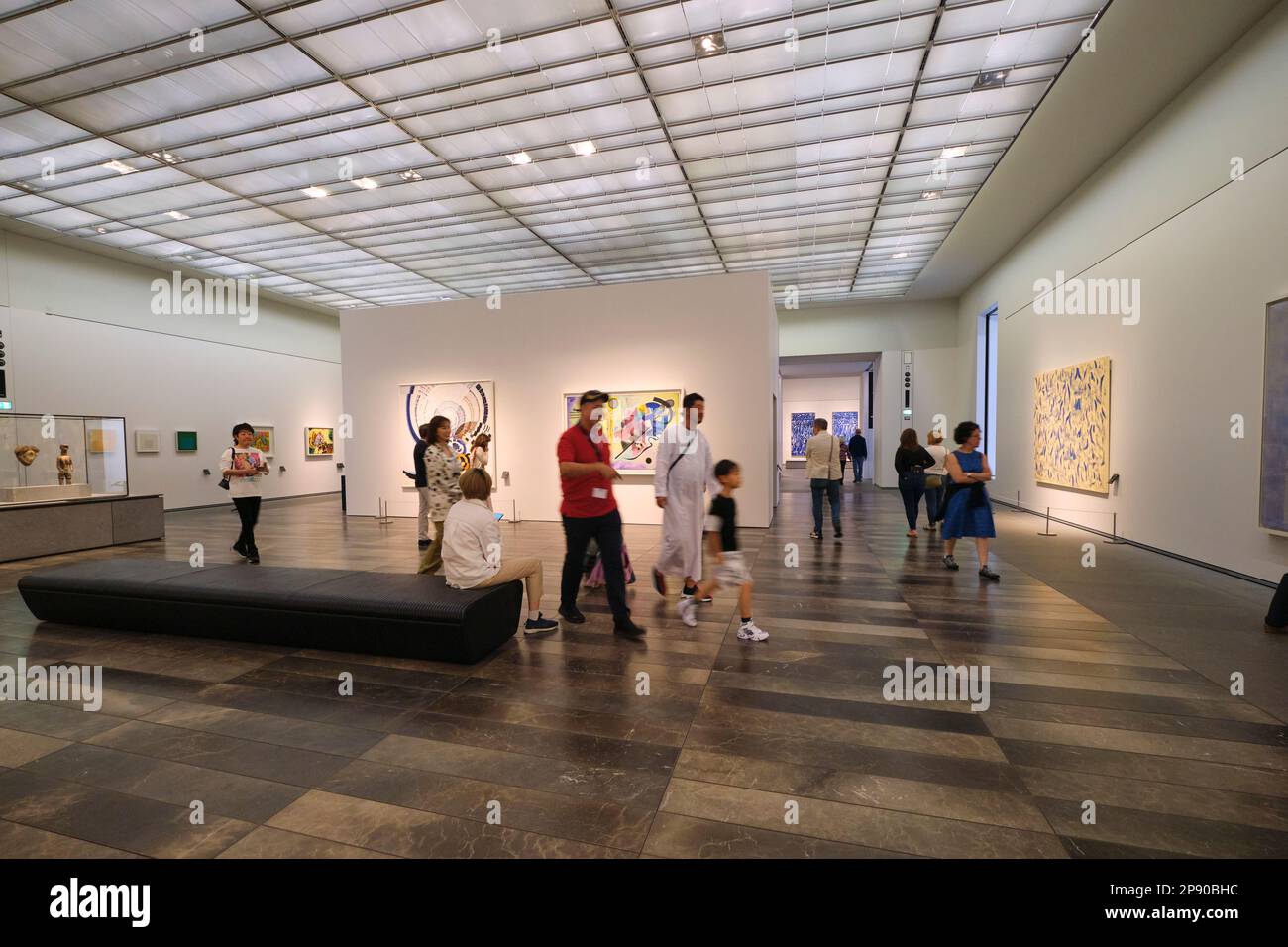 Touristen, Leute, die abstrakte moderne Kunst in einem Galerieraum genießen. Im Kunstmuseum des französischen Louvre in Abu Dhabi, Vereinigte Arabische Emirate. Stockfoto