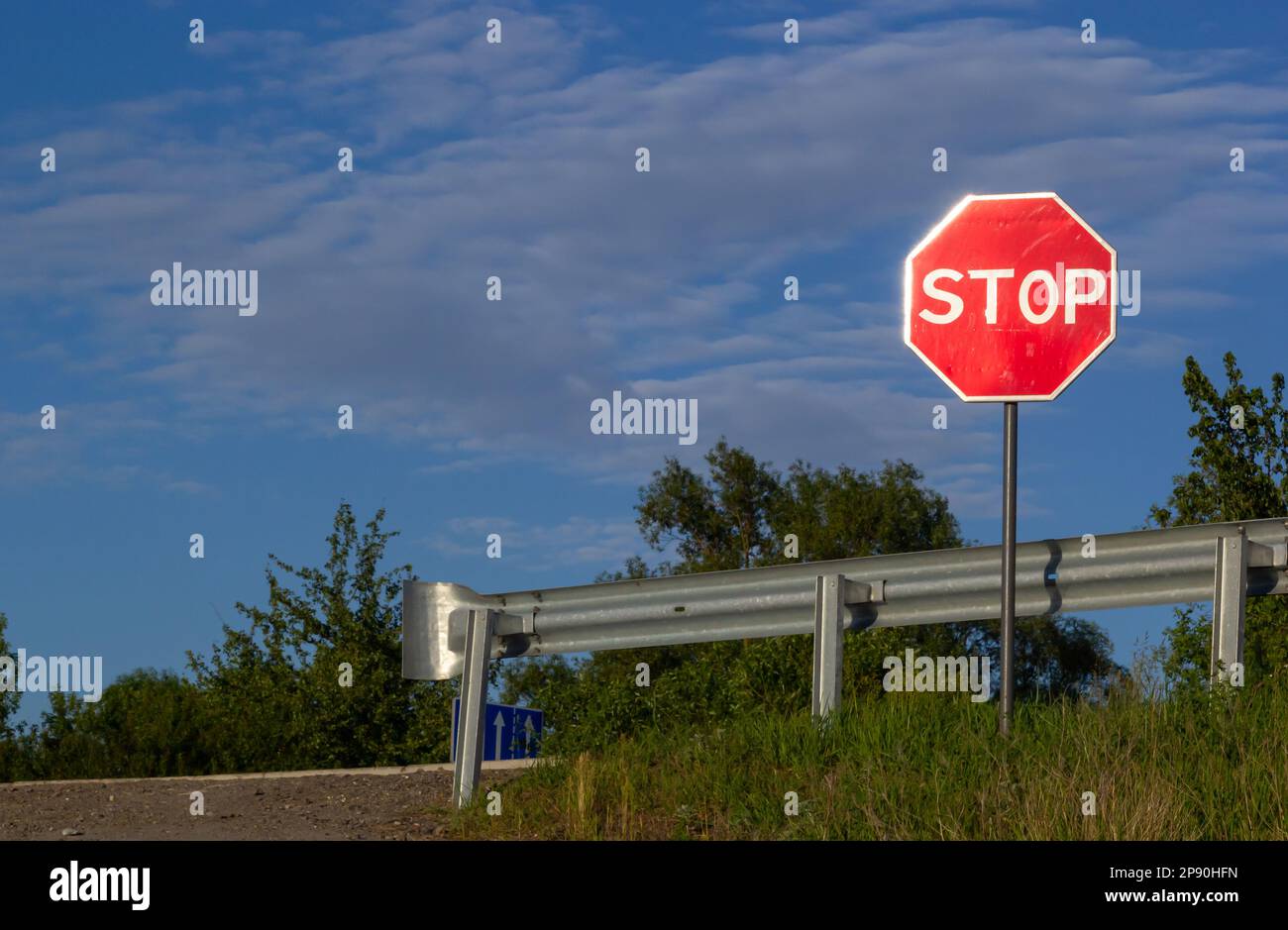 Rotes Stoppschild mit blauem Himmel und Wolken Hintergrund der Straße. Stockfoto