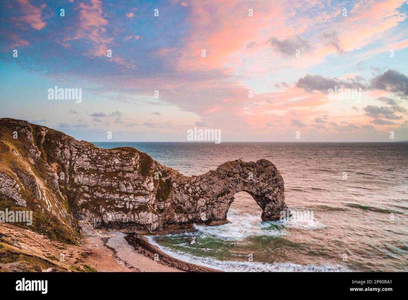 Sonnenuntergang am Durdle Door mit Blick auf Portland. Stockfoto