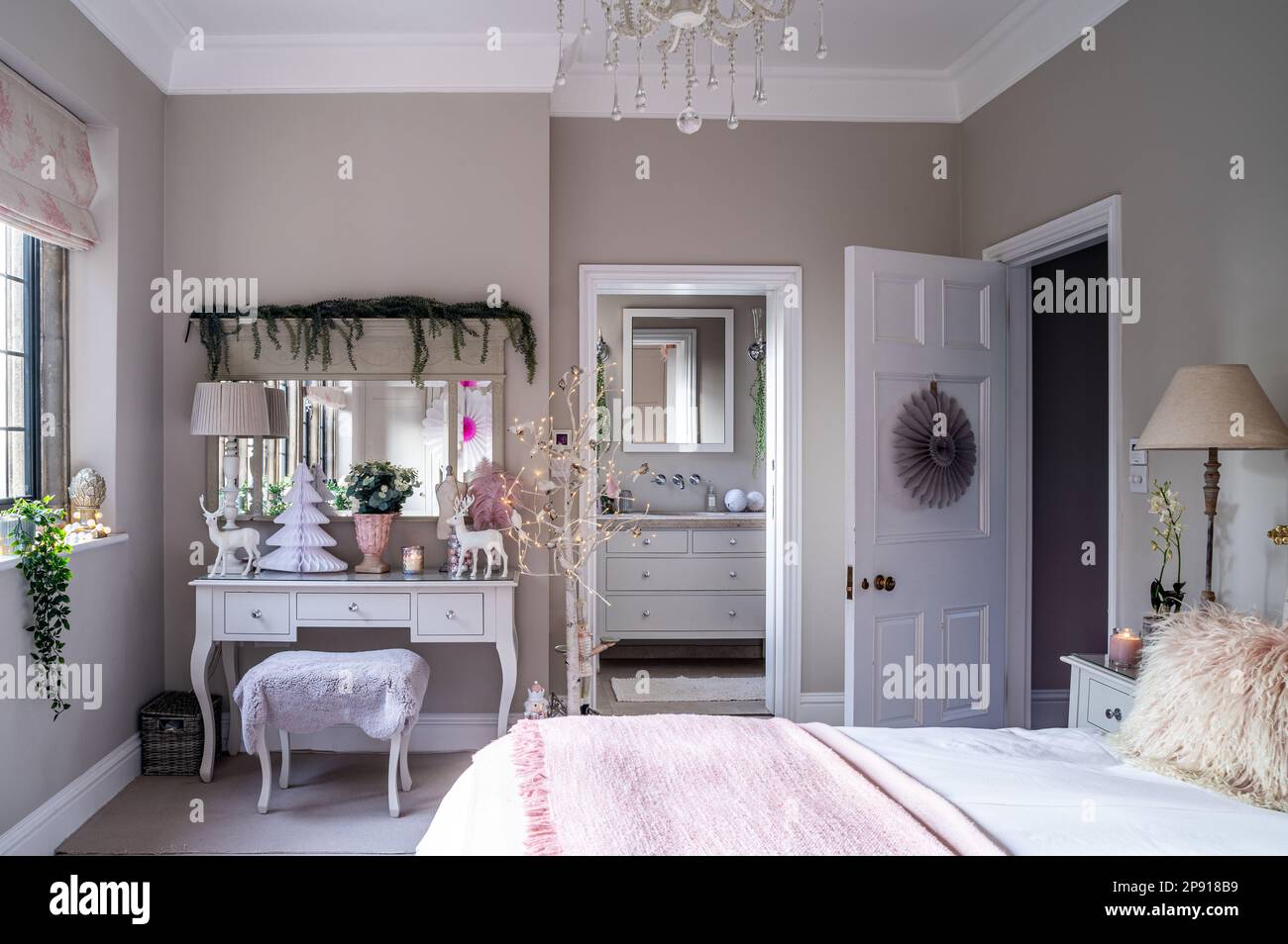 Mädchenschlafzimmer mit eigenem Badezimmer zu Weihnachten in einem Landhaus im Kunst- und Kunsthandwerksstil, Kent, Großbritannien Stockfoto