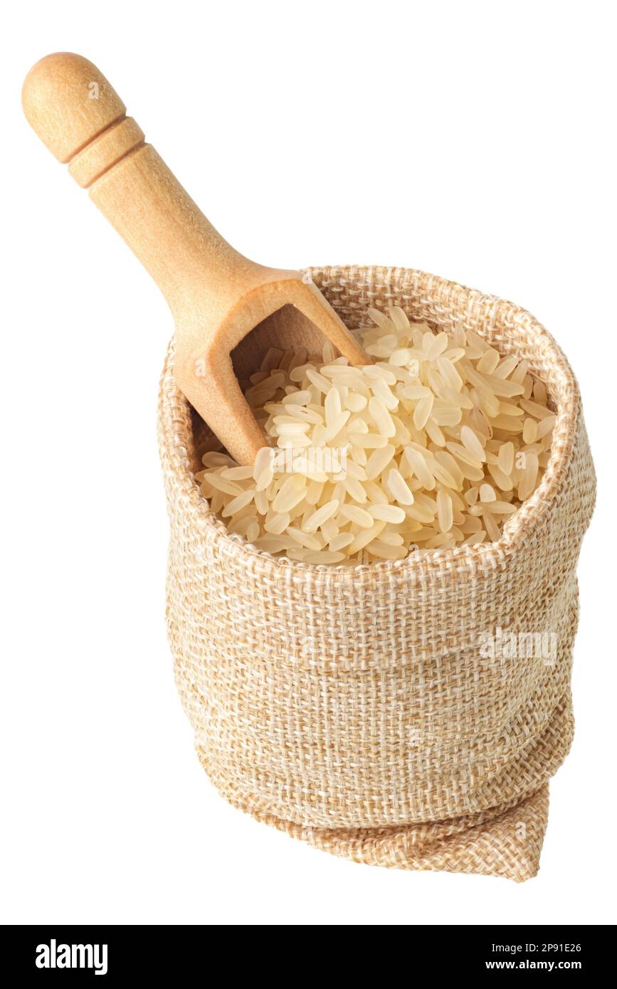 Ungekochter weißer Reis und Holzlöffel in einem rauen Leinenbeutel, isoliert auf weißem Hintergrund Stockfoto