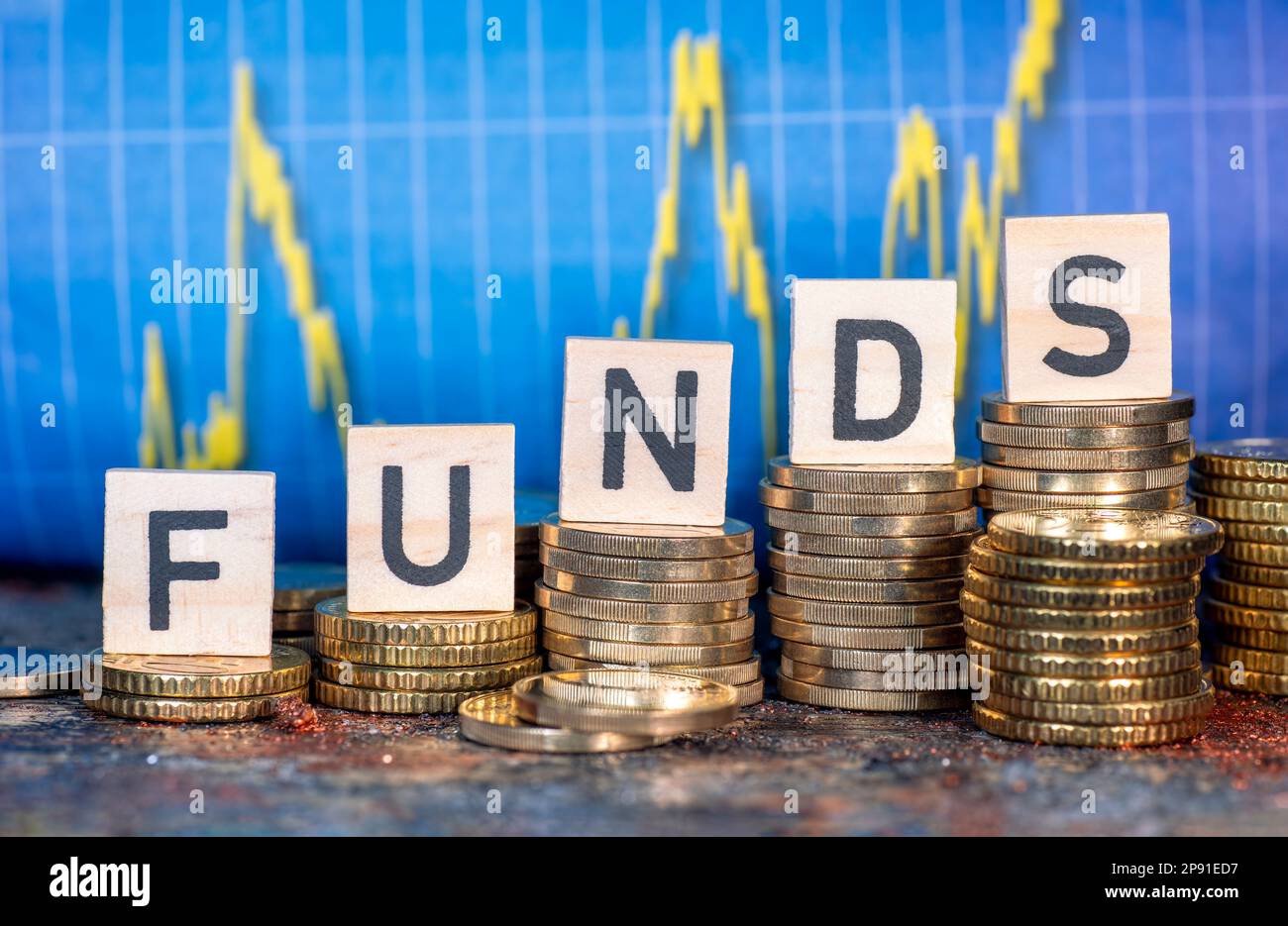 Mehrere Münzstapel und der Begriff "Fonds" und eine Tabelle mit Aktienkursen. Stockfoto