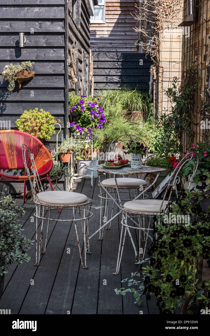 Verwitterte Tische und Stühle im Garten des Küstenhauses aus dem 19. Jahrhundert, Herne Bay, Kent, Großbritannien Stockfoto