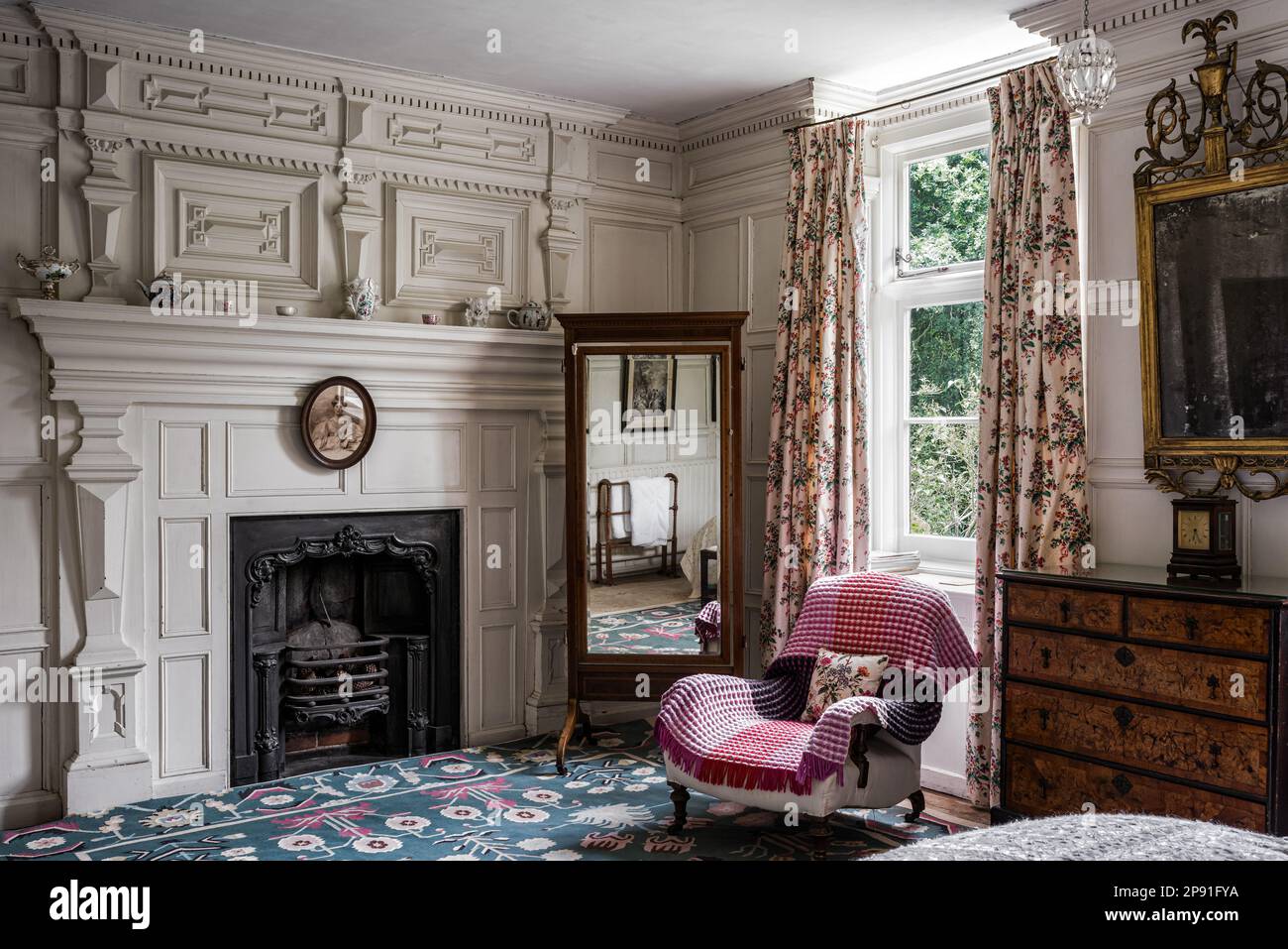 Standspiegel und Sessel im Fenster des Herrenhauses Wiveton Hall aus dem 17. Jahrhundert, Norfolk, Großbritannien Stockfoto