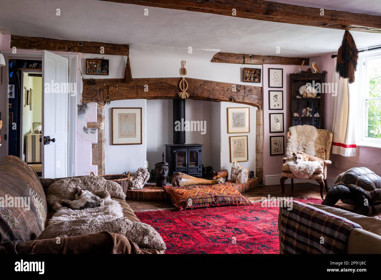 Gemischte Styles und Sammlerstücke im Wohnzimmer des Bauernhauses Tudor aus dem 16. Jahrhundert, Suffolk, Großbritannien. Stockfoto