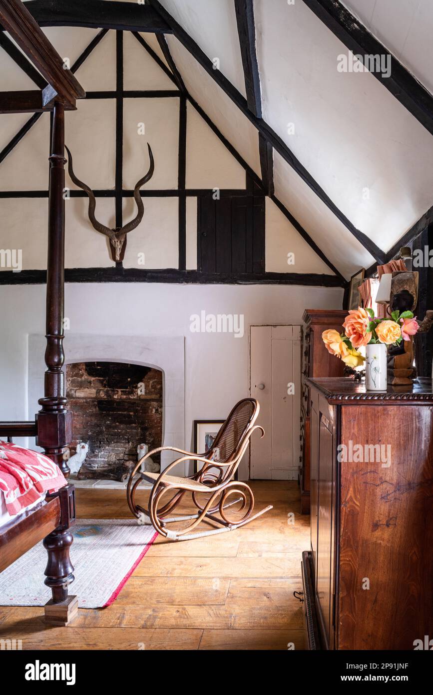 Antiker Schaukelstuhl und Schrank im Schlafzimmer im Dachgeschoss des Tudor-Bauernhauses aus dem 16. Jahrhundert, Suffolk, Großbritannien. Stockfoto