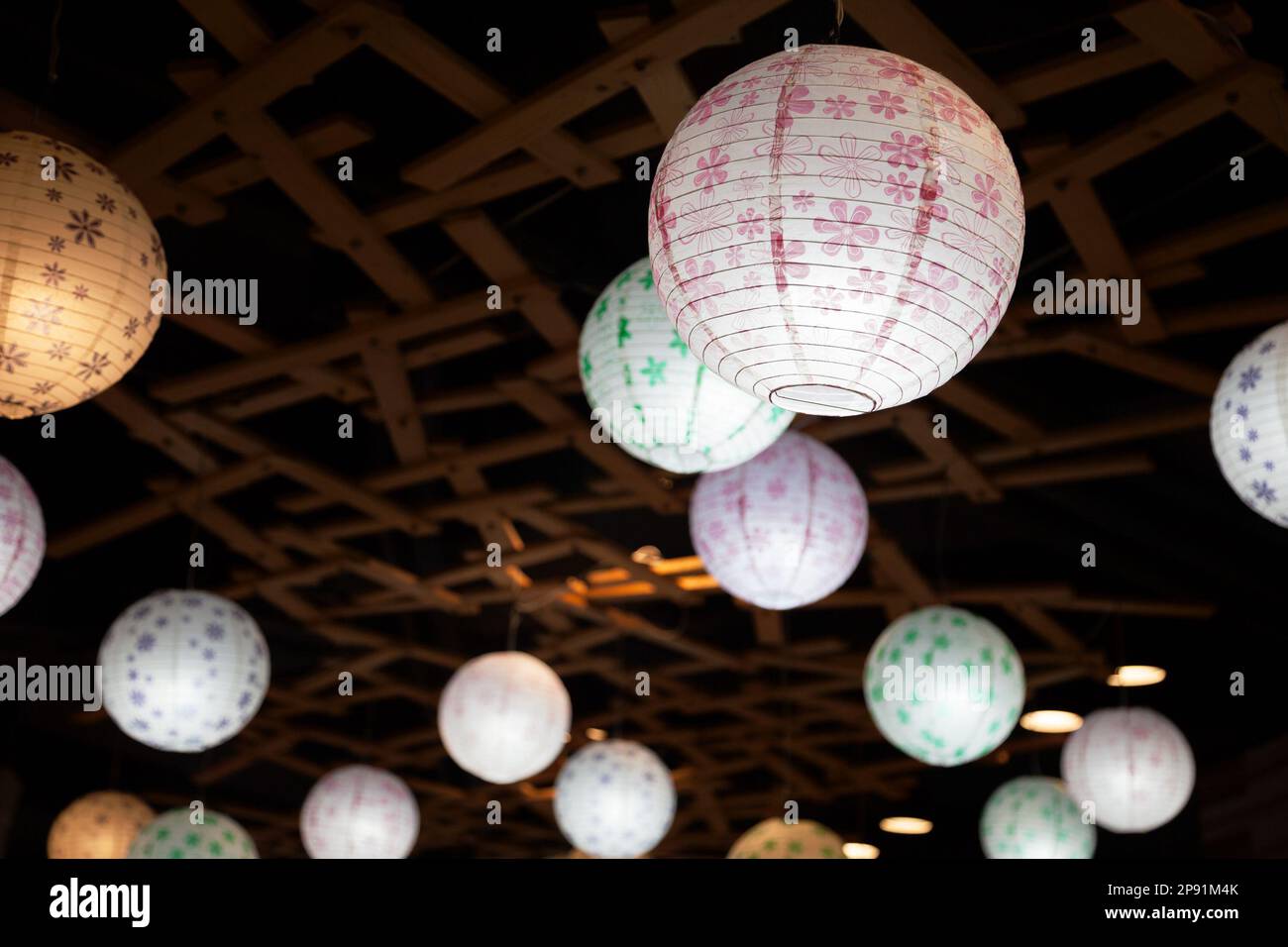 Viele weiße Runde chinesische Papierlaternen hängen in der Dunkelheit. Hypochondrischen Lampen Beleuchtung in der Nacht Stockfoto