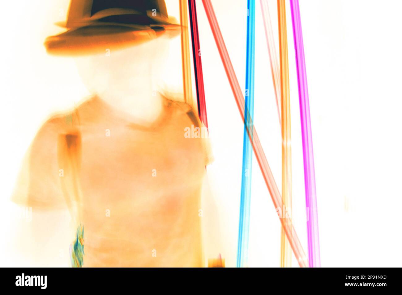 Verschwommener bewegter Mann mit Hut, der im Neonlicht tanzt. Person ohne Gesicht, verstecktes Identitätskonzept Stockfoto